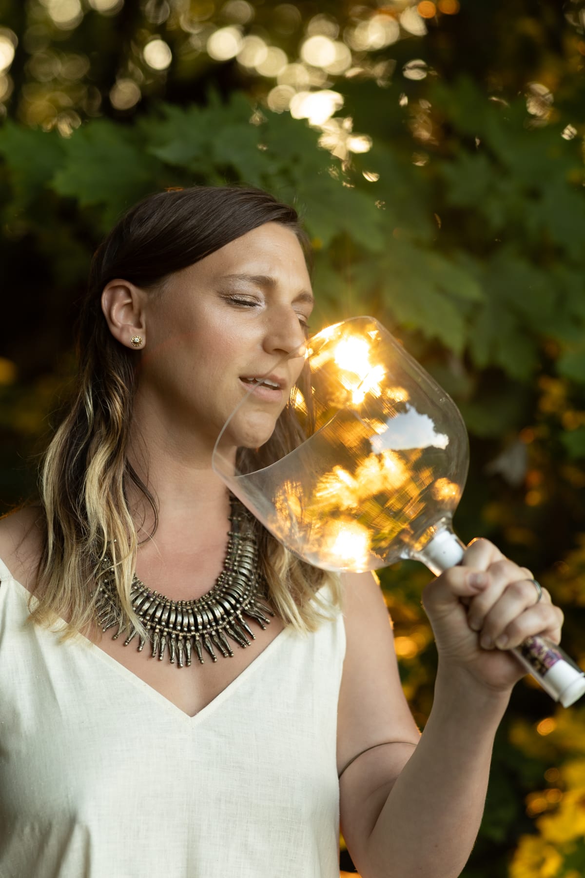 Katie singing into a crystal bowl in golden evening light